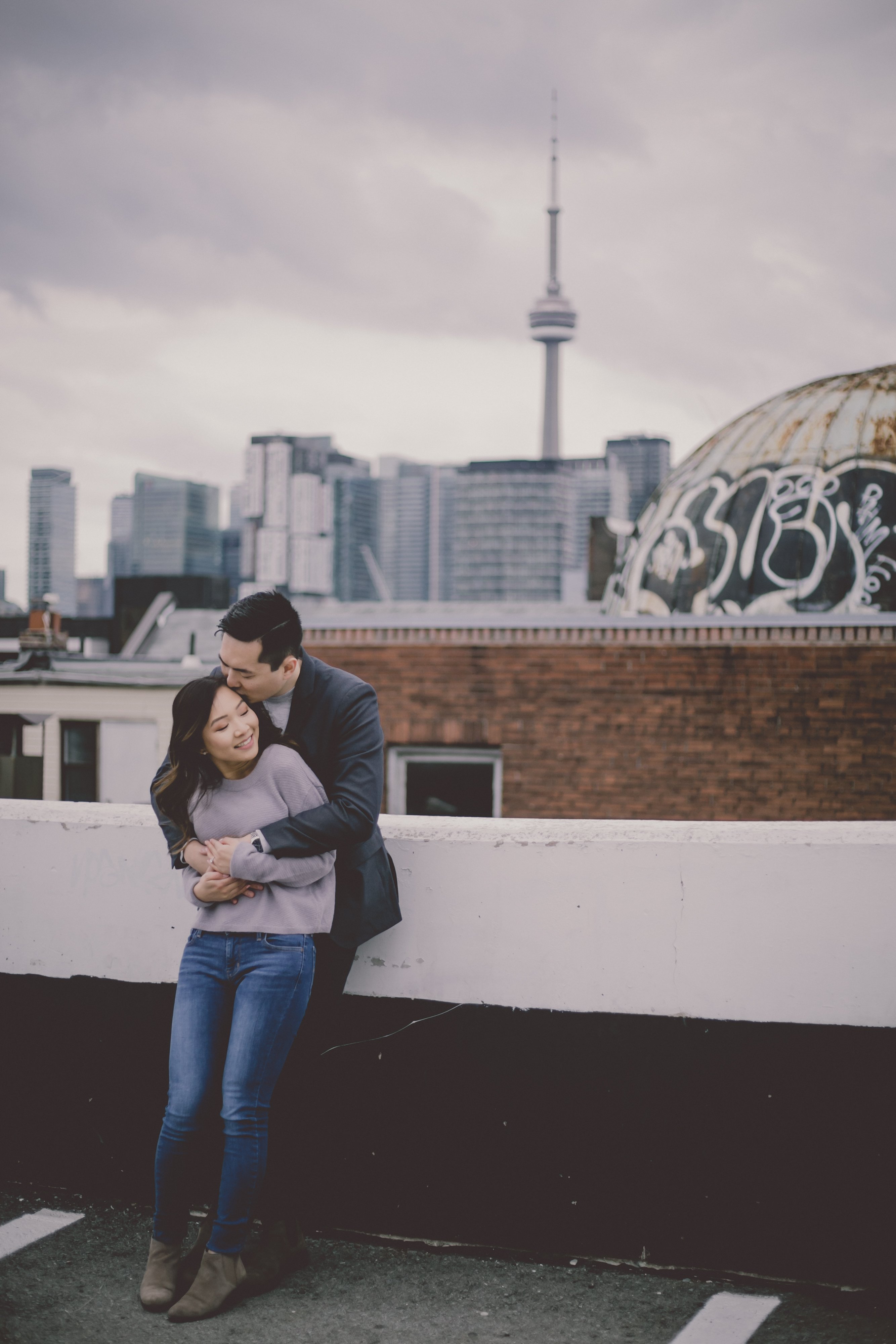 Toront skyline, couple on rooftop and view of Toronto skyline, engaged couple embracing on Toronto rooftop