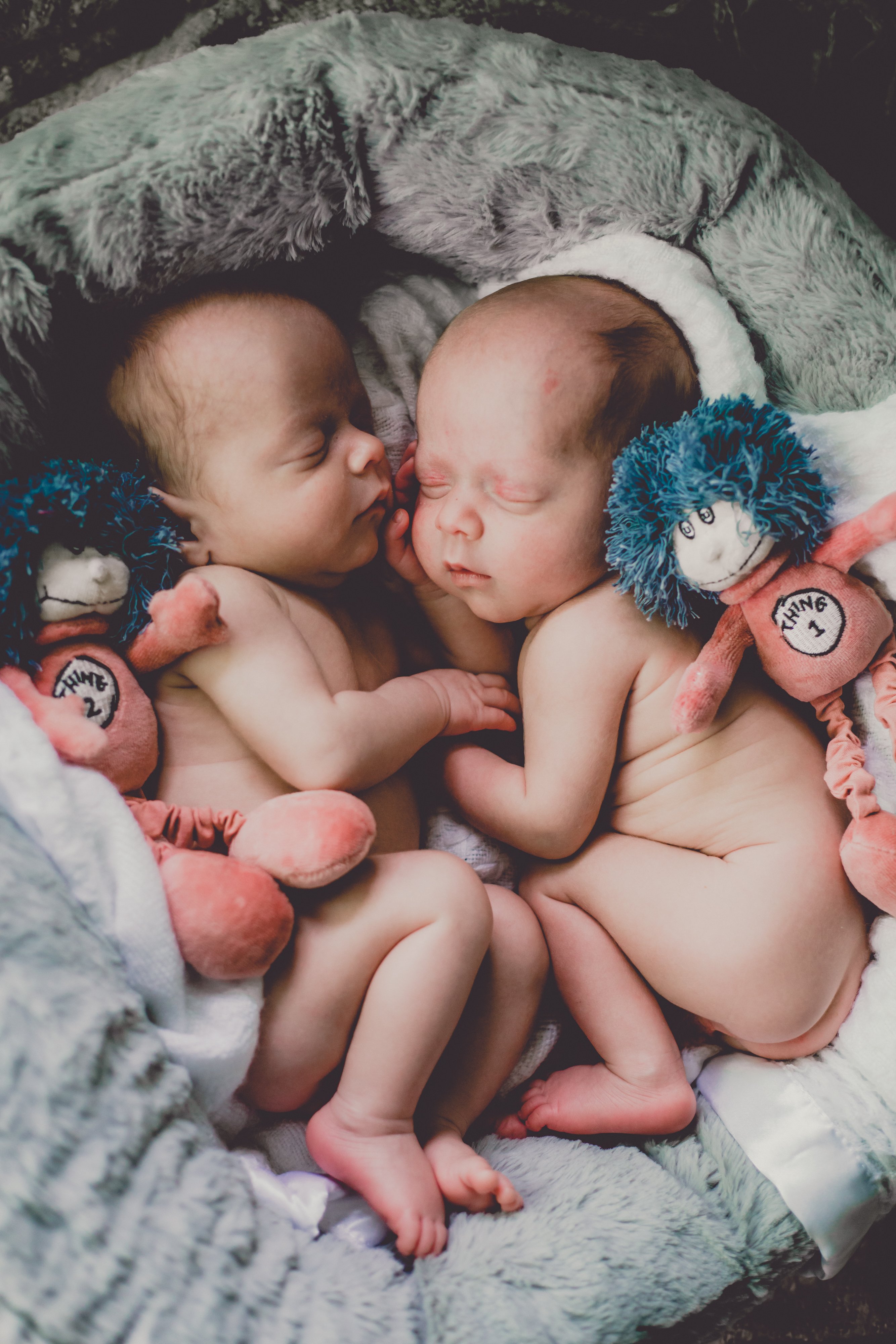 Newborn twins Aiden and Nolan photographed by Olive Studio while asleep in their baby cot. 