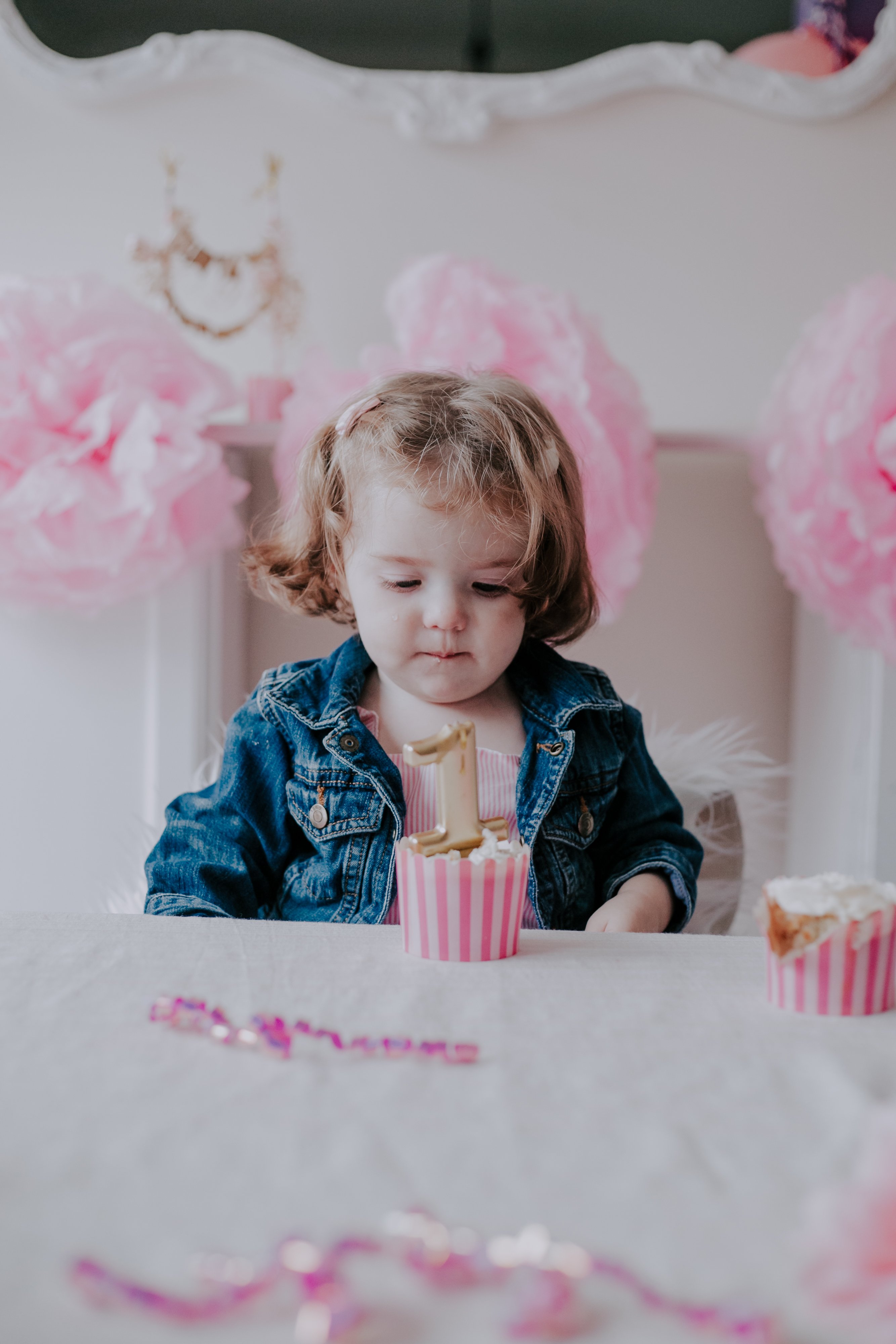 One-year-old photographed by Olive Studio with her birthday cupcakes at Cake Smash Session. 