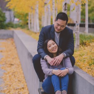 Engagement Photo Session in downtown Toronto with Liane and Victor in a seated embrace on one of the benches in front of, Osgoode Hall. Photographed by Olive Studio Photography.
