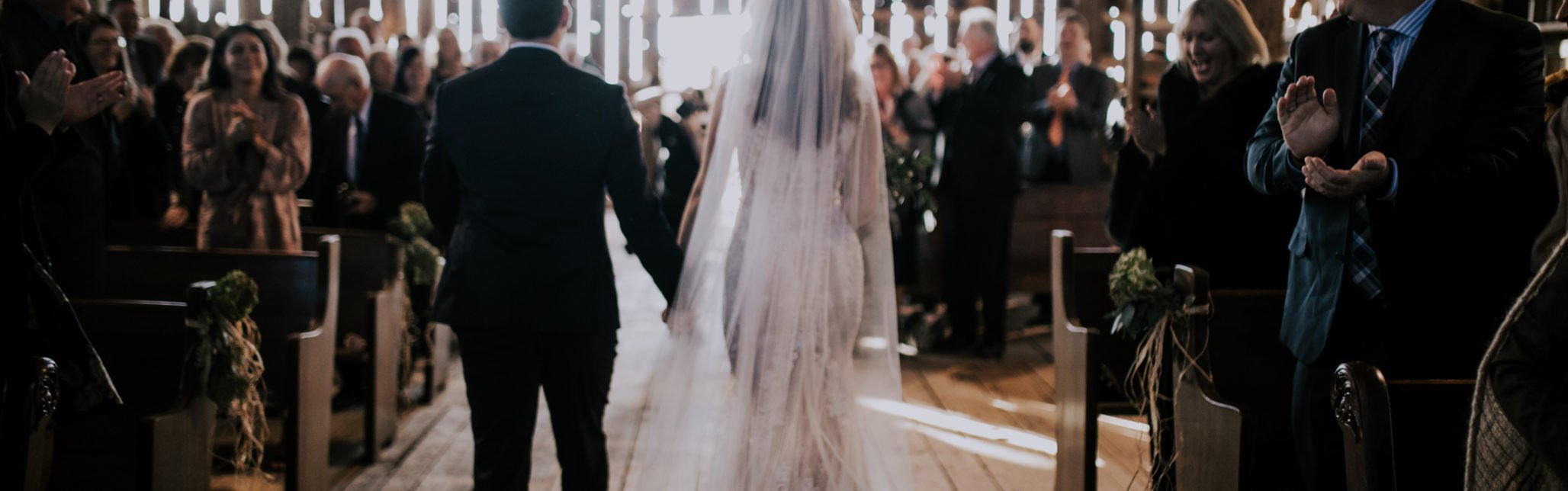 bride and groom walking down aisle in barn