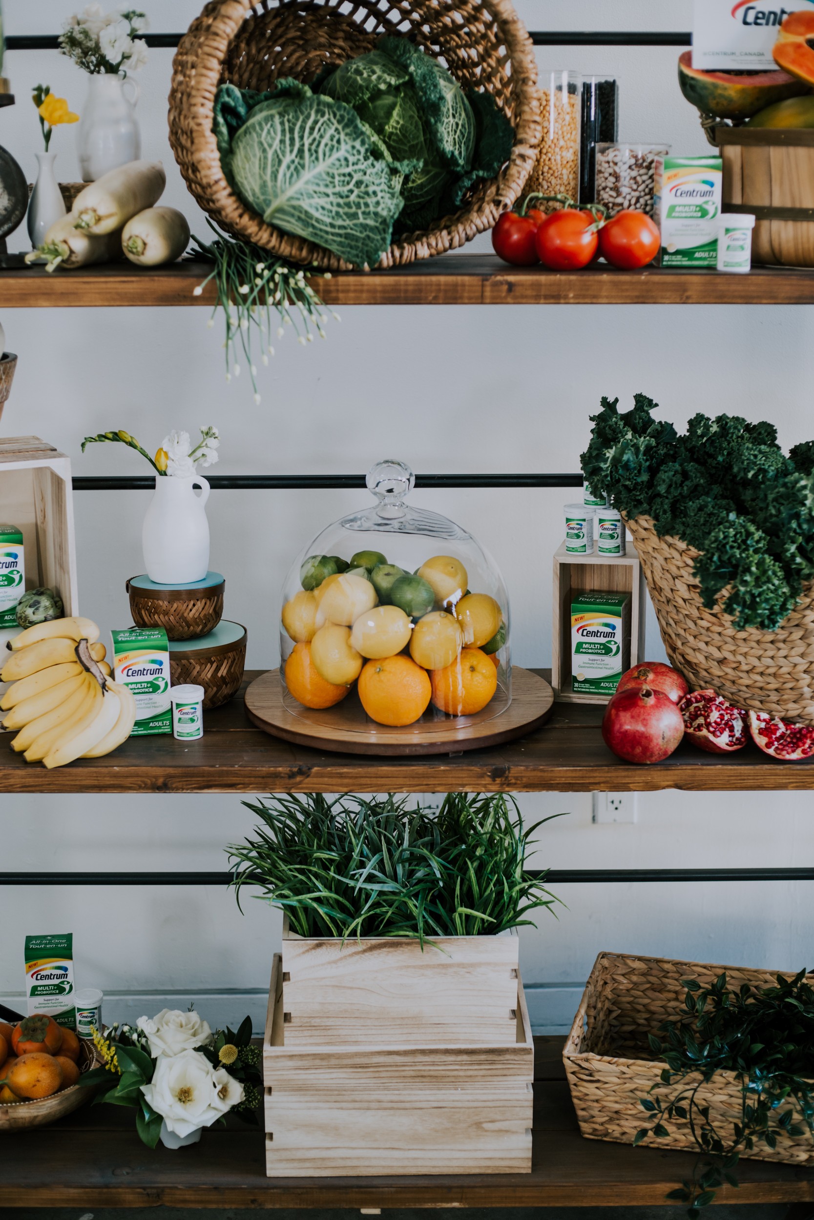 fruits and veggies on a shelf to promote centrum's multi probiotic vitamin. lemons, limes, oranges, pomegranate, cabbage, tomatoes to name a few.