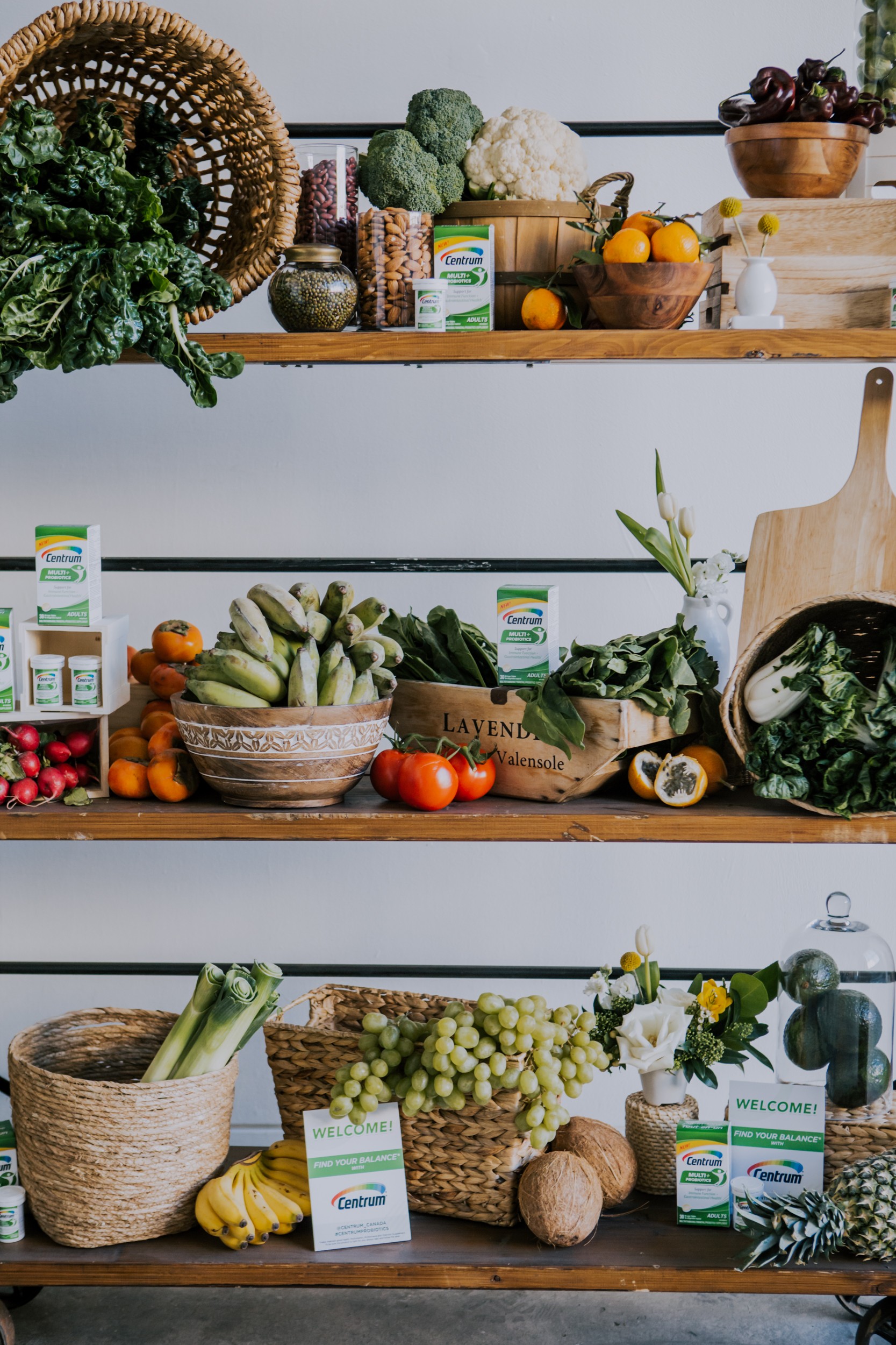 3 wooden shelves are filled with healthy greens, fruits, veggies, and nuts to help promote the new multi probiotic vitamin