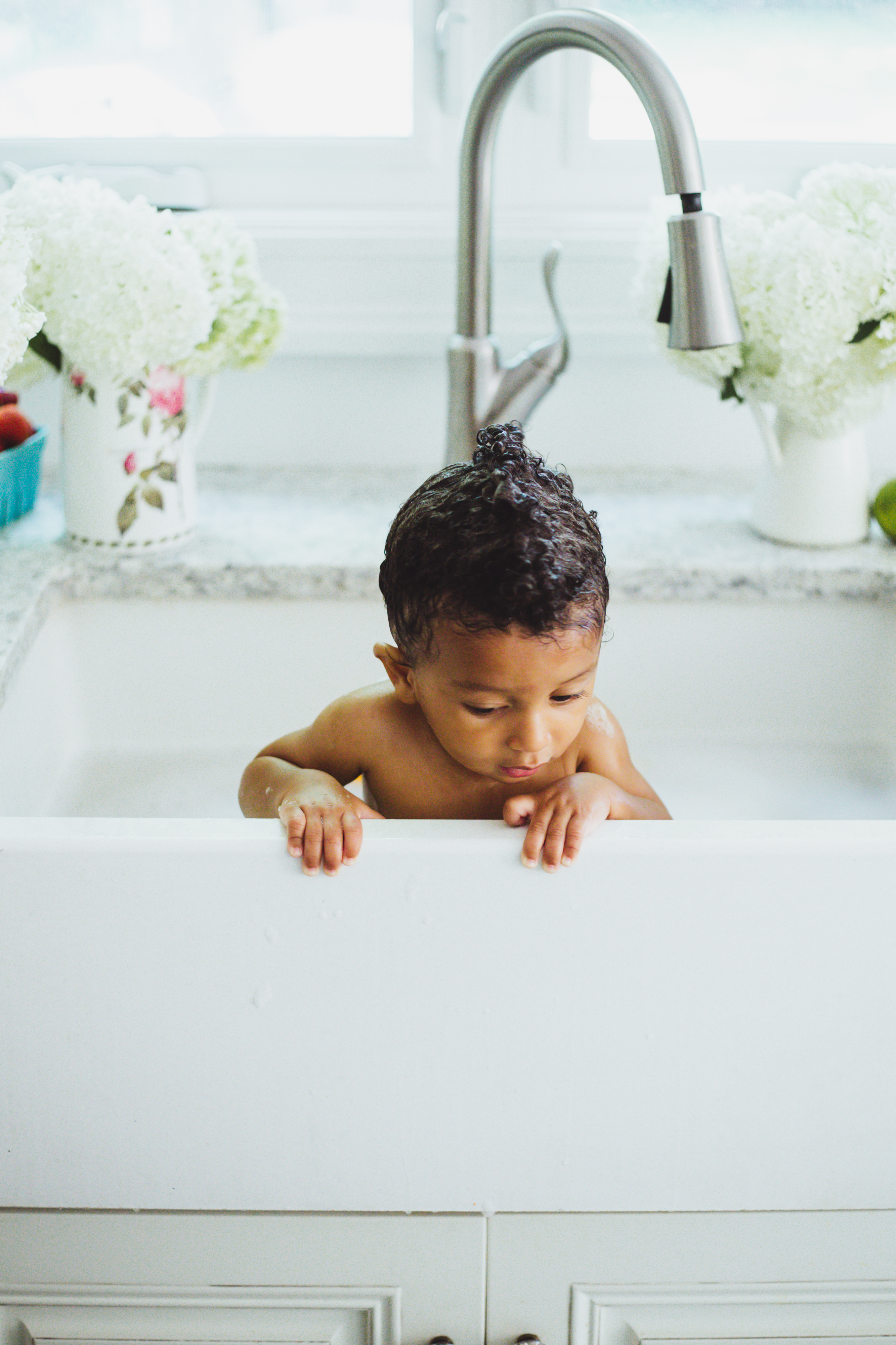 mixed baby boy has kitchen sink bubble bath
