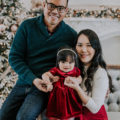 asian mother and father hold daughter