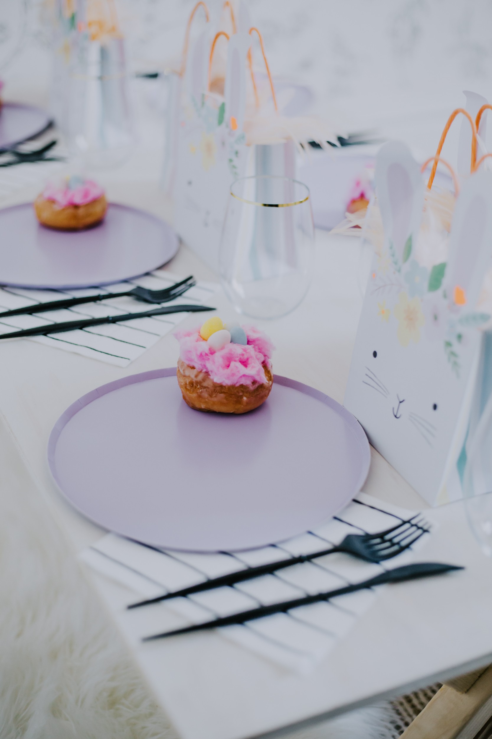 Pastel Easter tablescape with candy floss donut topped with mini eggs