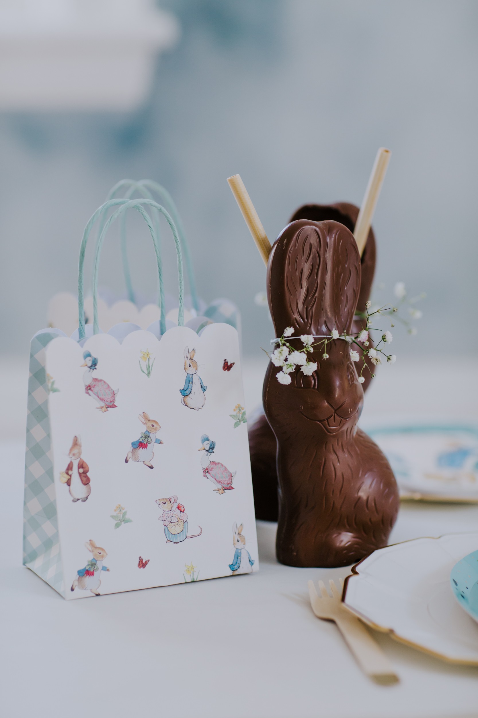 chocolate bunny is used as a glass and sits on a table holding milk